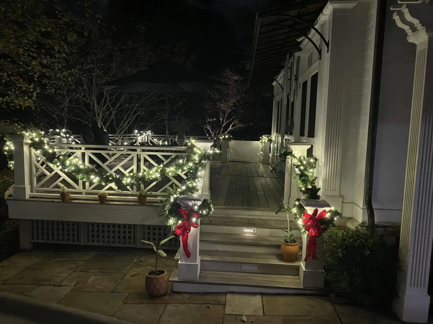 Porch railing and steps wrapped in garland and lights at night